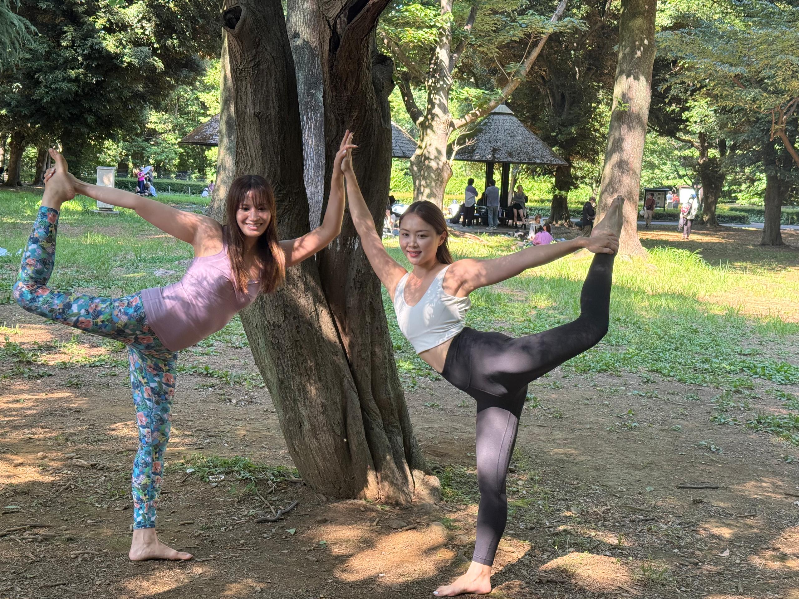Two women enjoying a yoga session in Yoyogi Park, Tokyo